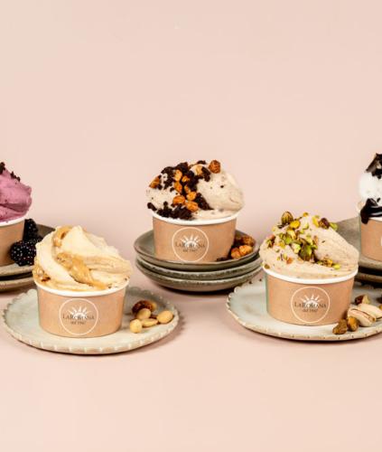 Five cups of ice cream with various flavors and toppings.
